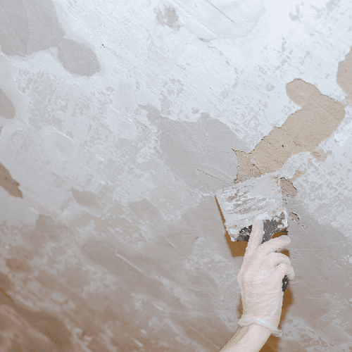 a worker puttying holes in the walls with a tool