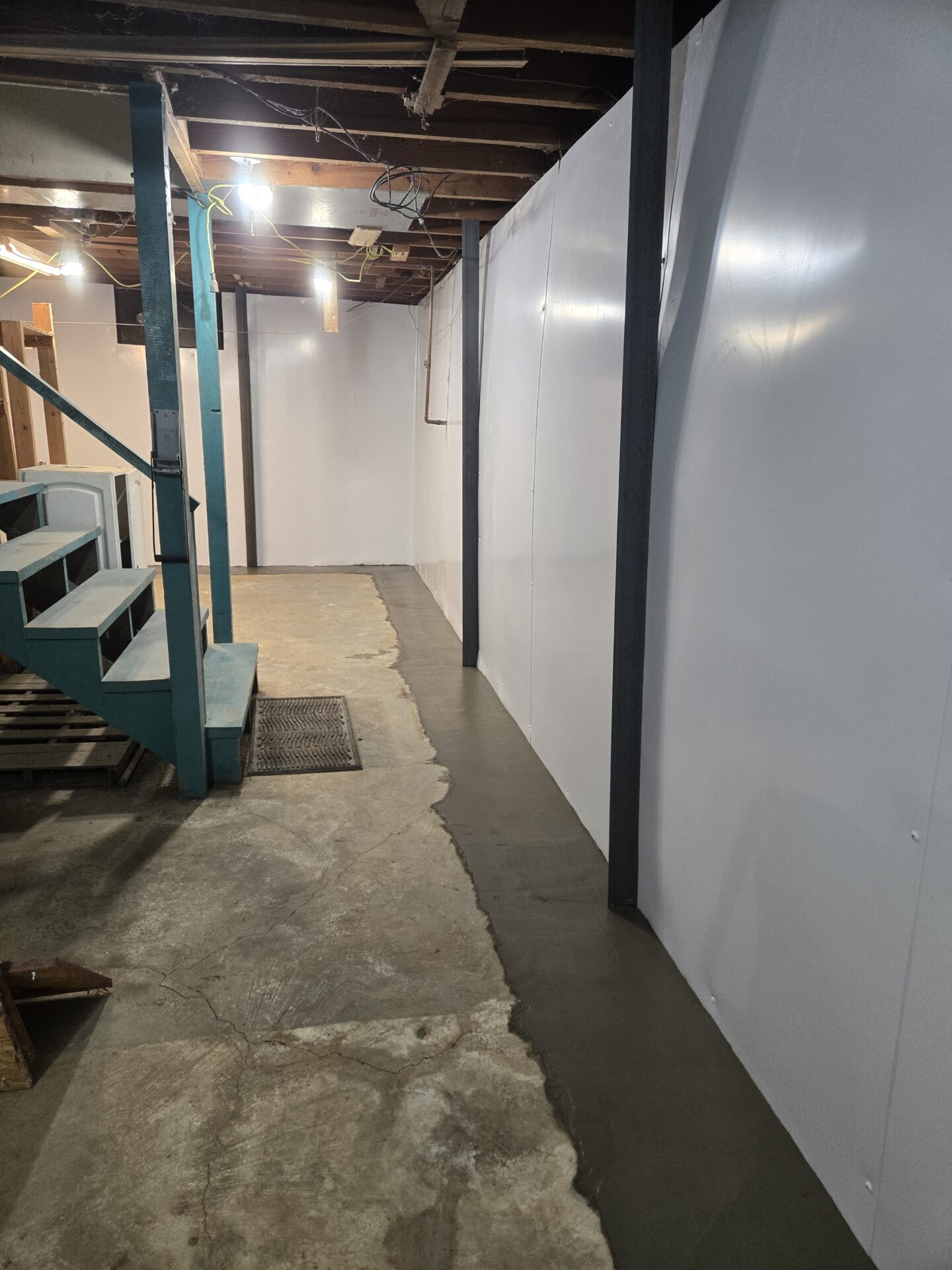 Tilted view of a basement with exposed ductwork, unfinished walls, and a wooden ladder